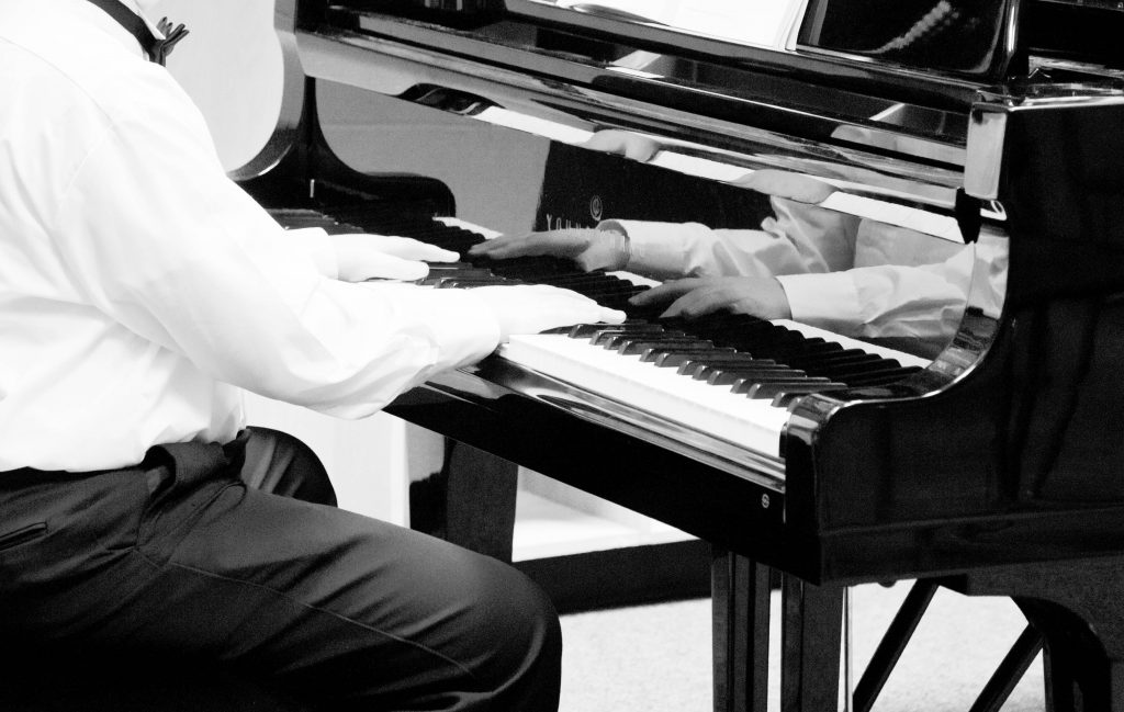A student using both hands at the piano.