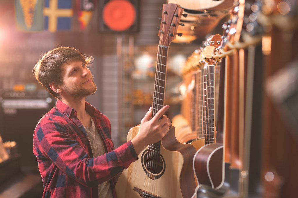 A young man chooses a guitar for his first musical instrument.