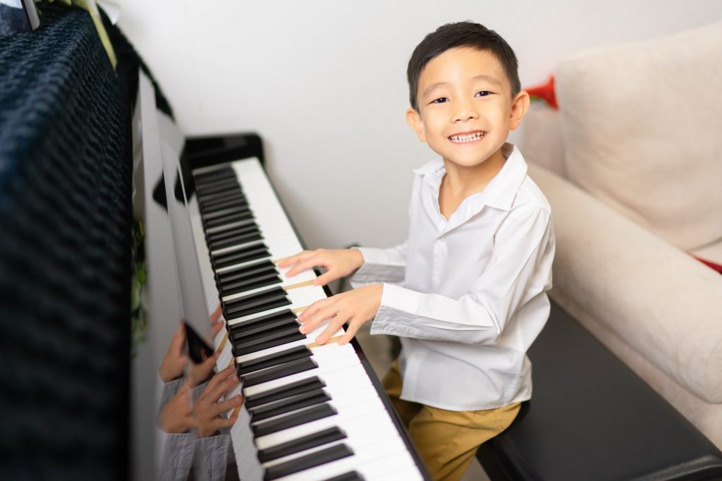 A boy playing the piano as a preparatory instrument to other instruments.