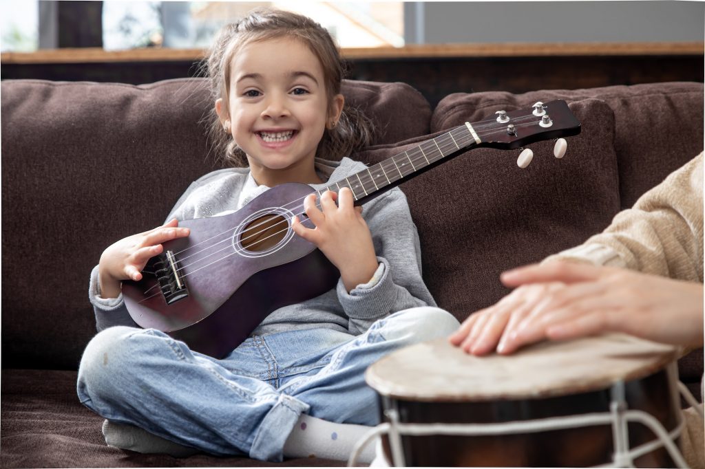 A girl learning the ukulele as a preparatory instrument to the guitar.