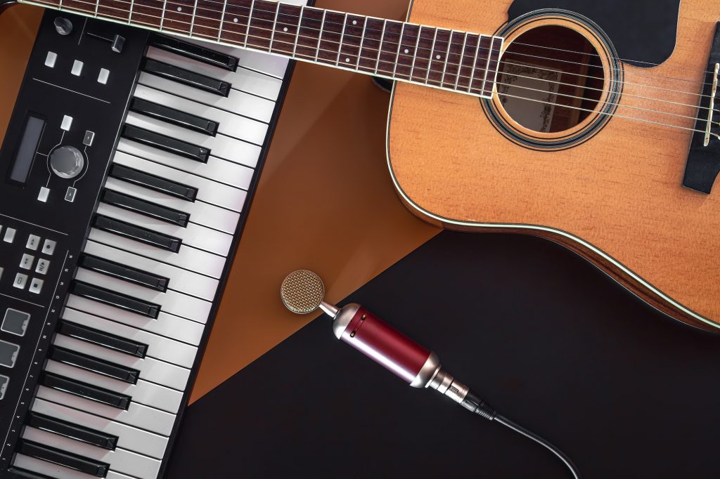 Flat lay, music background with acoustic guitar and piano.