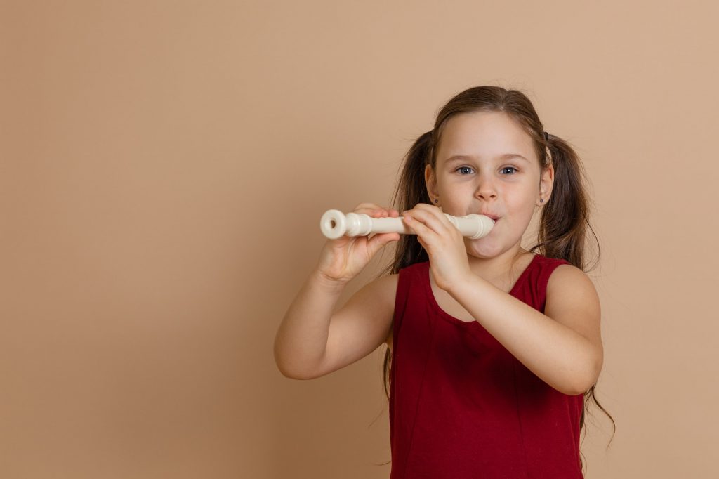 A girl learning the recorder, a preparatory instrument for the flute.